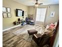 Comfortable living room featuring wood-look floors, cozy seating, and a large window with natural light at 3021 W Trapanotto Rd, Phoenix, AZ 85086