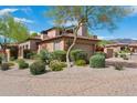 Charming home exterior with desert landscaping, a stone chimney, and a tile roof at 7701 E Golden Eagle Cir, Gold Canyon, AZ 85118