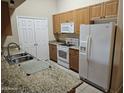 Well-equipped kitchen featuring granite countertops, stainless steel sink, and white appliances at 10136 E Southern Ave # 2048, Mesa, AZ 85209