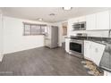 Bright kitchen featuring stainless steel appliances, white cabinetry, and modern gray flooring at 1108 N Esther St, Tempe, AZ 85288