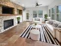 Bright living room with a stone fireplace, ceiling fan, and white sofas at 12644 N 152Nd Ave, Surprise, AZ 85379