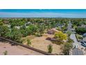 An elevated view of a sprawling property, featuring desert landscaping, mature trees, and a terracotta-roofed home at 1637 S Los Alamos Cir, Mesa, AZ 85204