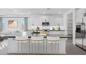 Bright, open kitchen features a large center island with barstool seating and modern appliances at 18123 W Hiddenview Dr, Goodyear, AZ 85338