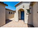 Front door entry with paver approach and tan stucco exterior at 18150 W Tanglewood Dr, Goodyear, AZ 85338