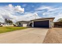 Well-kept single-story home with a blue garage door and a large driveway, perfect for extra parking at 18309 N 39Th Ave, Glendale, AZ 85308