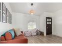 Bright, cozy living room featuring a rustic light fixture, wood floors, and large window at 18309 N 39Th Ave, Glendale, AZ 85308