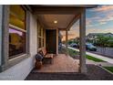 Inviting front porch with brick flooring, wooden bench and decorative accents, perfect for enjoying quiet moments at 1919 W Hide Trl, Phoenix, AZ 85085