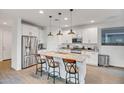 Modern kitchen boasts white cabinets, granite countertops, stainless steel appliances, and a large center island with seating at 1919 W Hide Trl, Phoenix, AZ 85085