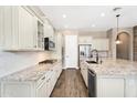 Bright kitchen with white cabinets, granite countertops, stainless appliances, and tile backsplash at 22296 E Maya Rd, Queen Creek, AZ 85142