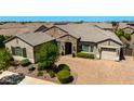 Beautiful stone accents highlight this single-story home with manicured landscaping and a paver driveway at 22302 E Russet Rd, Queen Creek, AZ 85142
