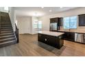 Open kitchen featuring a large island, stainless steel appliances, dark cabinets, and tile flooring at 2491 N 149Th Ln, Goodyear, AZ 85395