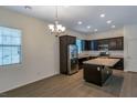 Kitchen with stainless steel appliances, dark cabinets, tile flooring, and a window over the sink at 2491 N 149Th Ln, Goodyear, AZ 85395