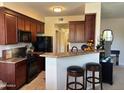 Charming kitchen with breakfast bar, black appliances, and ample cabinet space at 29606 N Tatum Blvd # 276, Cave Creek, AZ 85331