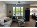 Inviting living room with large window, ceiling fan, and adjacent dining area at 29606 N Tatum Blvd # 276, Cave Creek, AZ 85331