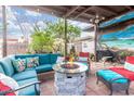 Charming outdoor patio boasts a stone fire pit, plush seating, mural, and a cozy ambiance at 29972 N Bryce Trl, San Tan Valley, AZ 85144