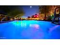 Beautiful swimming pool with colorful lights and landscaped yard, creating an inviting outdoor space at 29972 N Bryce Trl, San Tan Valley, AZ 85144