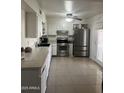 Bright kitchen features stainless steel appliances, white cabinetry and a clean tile floor at 3020 N 64Th Dr, Phoenix, AZ 85033