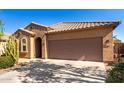 Charming single-story home with desert landscaping, tile roof, and a two-car garage, all under a clear blue sky at 37852 W Merced St, Maricopa, AZ 85138