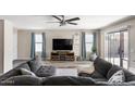 Spacious living room with a modern ceiling fan, decorative accents, and cozy sectional sofa at 42430 W Oakland Dr, Maricopa, AZ 85138