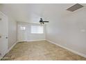 Bright and airy living room with tile flooring, ceiling fan, and large window at 6120 W Keim Dr, Glendale, AZ 85301