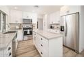 Bright kitchen featuring white cabinets, stainless appliances, a center island, and wood flooring at 6130 E Windsor Ave, Scottsdale, AZ 85257