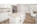 Bright kitchen featuring white cabinets, stainless appliances, a center island, and wood flooring at 6130 E Windsor Ave, Scottsdale, AZ 85257