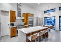 Bright kitchen featuring stainless appliances, wood cabinetry, and large central island with bar stool seating at 12809 N 67Th St, Scottsdale, AZ 85254
