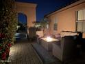 Inviting backyard patio with fire pit, cushioned seating, and lush landscaping for relaxing evenings at 16370 W Granada Rd, Goodyear, AZ 85395