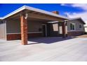 Attached carport with brick columns provides ample covered parking with a well-lit entrance to the home at 2035 W Claremont St, Phoenix, AZ 85015