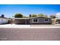 Attractive exterior view shows a single story house with attached carport and landscaped front at 2035 W Claremont St, Phoenix, AZ 85015