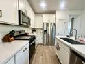 Well-equipped kitchen with stainless steel appliances, white cabinets, and quartz countertops at 2134 N Marketside Ave, Buckeye, AZ 85396