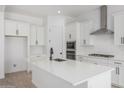 Bright, open kitchen features white cabinets, stainless steel appliances, and a large island at 24054 N 171St Dr, Surprise, AZ 85387