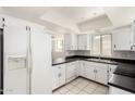 Traditional kitchen featuring white cabinets, black countertops, and modern appliances at 7061 E Broadway Rd # 48, Mesa, AZ 85208