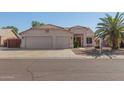 Charming home showcasing a well-maintained front yard, three-car garage, and beautiful desert landscaping at 8757 W El Caminito Dr, Peoria, AZ 85345