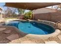 Backyard pool featuring custom rock accents and a shaded cover, perfect for enjoying sunny days outdoors at 8757 W El Caminito Dr, Peoria, AZ 85345