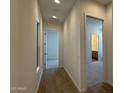 Hallway featuring wood floors connecting bedrooms and bathrooms in the house at 11422 E Utah Ave, Mesa, AZ 85212