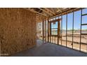 This image captures the interior framing of a home, with exposed studs, window openings, and a concrete floor at 11422 E Utah Ave, Mesa, AZ 85212