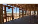 A home's interior framing displays structural elements, window openings, and the unfinished concrete floor at 11422 E Utah Ave, Mesa, AZ 85212