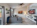 Cozy living room with a plush gray sofa, decorative shelves, and a sliding door to the outdoors at 1282 W Kesler Ln, Chandler, AZ 85224