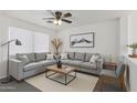 Cozy living room featuring an L-shaped couch and a natural light from a large window at 12825 W Virginia Ave, Avondale, AZ 85392