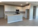 Modern kitchen with white cabinets, an island, and stainless steel appliances at 17016 W Cavedale Dr, Surprise, AZ 85387