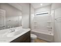 Clean, well-lit bathroom with a shower-tub combination, dark wood vanity and sink, and a tiled floor at 17770 W Getty Dr, Goodyear, AZ 85338