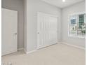 Bright bedroom with neutral carpet, a large window, and a closet with sliding doors provides ample space at 17770 W Getty Dr, Goodyear, AZ 85338