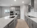 Modern kitchen with stainless steel appliances, island, quartz countertops, and designer backsplash at 17791 W Getty Dr, Goodyear, AZ 85338
