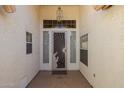 Covered front entryway featuring a decorated security door with a hanging light fixture at 2009 N 125Th Ave, Avondale, AZ 85392