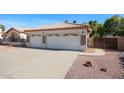 View of the garage with three car spaces and decorated with some stone accents at 2009 N 125Th Ave, Avondale, AZ 85392