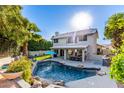 Relaxing backyard with sparkling pool, lush landscaping, and outdoor dining set at 21121 N 63Rd Dr, Glendale, AZ 85308