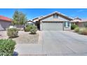 Inviting single-story home with a two car garage, desert landscaping and a tile roof at 2384 E Santiago Trl, Casa Grande, AZ 85194
