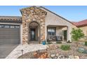 Charming home featuring desert landscaping, stone accents, and a welcoming covered porch at 25920 W Westcott Dr, Buckeye, AZ 85396