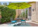 Private patio with a small dining set, an umbrella, and lush greenery at 27688 N 125Th Dr, Peoria, AZ 85383